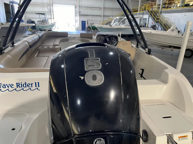 Slide: The Image of 2021 Hurricane SunDeck Sport 201 OB boat with 150 HP engine in a warehouse setting. - 13