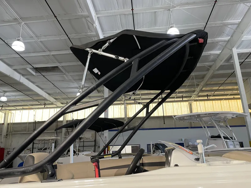 Slide: The Image of 2021 Hurricane SunDeck Sport 201 OB boat with black canopy in a showroom. - 15