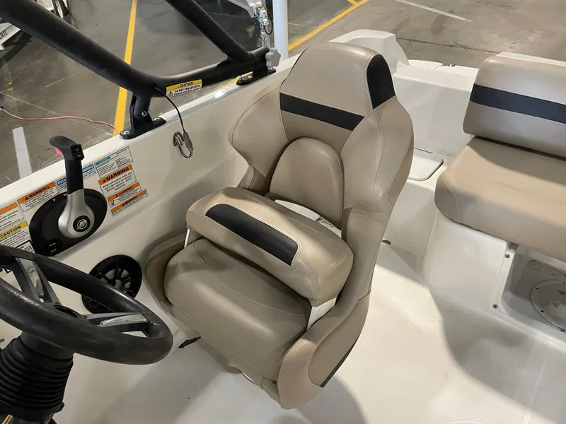 Slide: The Image of 2021 Hurricane SunDeck Sport 201 OB boat interior with beige captain's seat and steering wheel. - 22