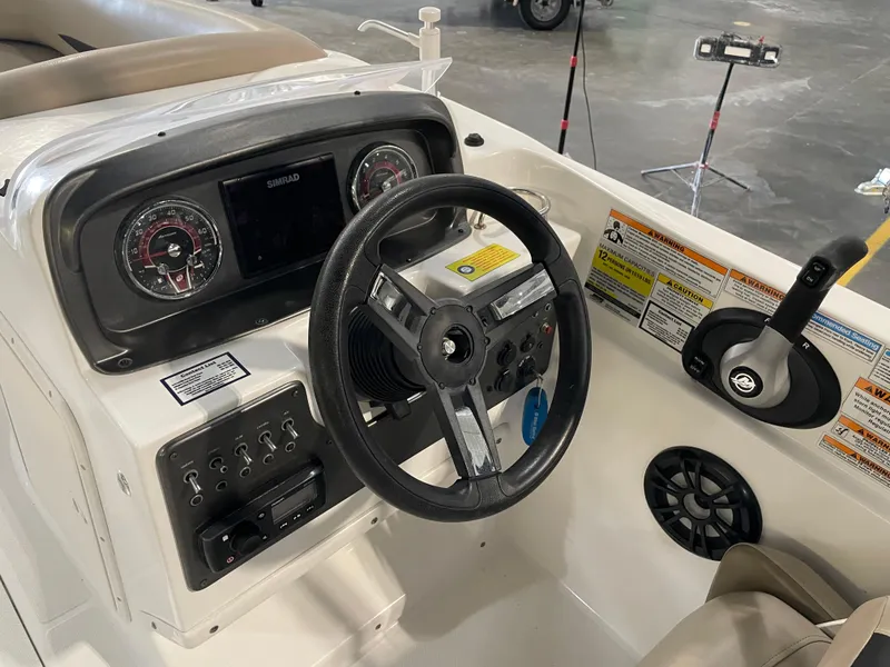 Slide: The Image of 2021 Hurricane SunDeck Sport 201 OB boat dashboard with steering wheel and control panel. - 24