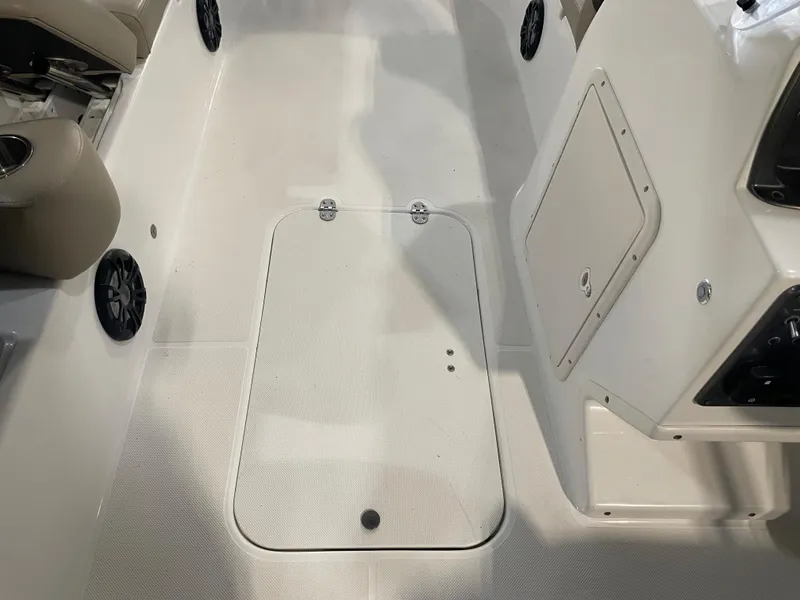 Slide: The Image of 2021 Hurricane SunDeck Sport 201 OB boat interior with storage compartment and speakers. - 28