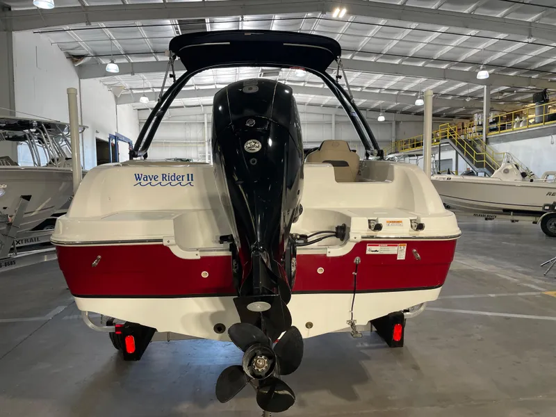 Slide: The Image of 2021 Hurricane SunDeck Sport 201 OB boat in a warehouse, rear view with outboard motor. - 9