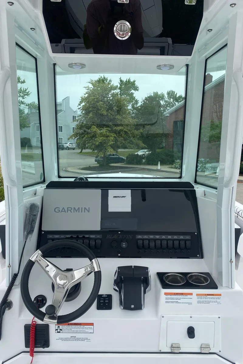 Slide: The Image of 2025 Blackfin 252 CC boat dashboard with Garmin navigation system and steering wheel. - 11