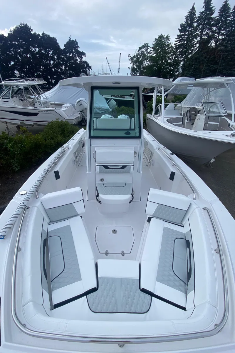 Slide: The Image of 2025 Blackfin 252 CC boat with spacious seating, docked among other boats. - 15