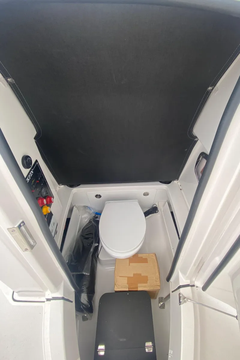 Slide: The Image of 2025 Blackfin 252 CC boat interior with compact marine toilet and storage. - 17