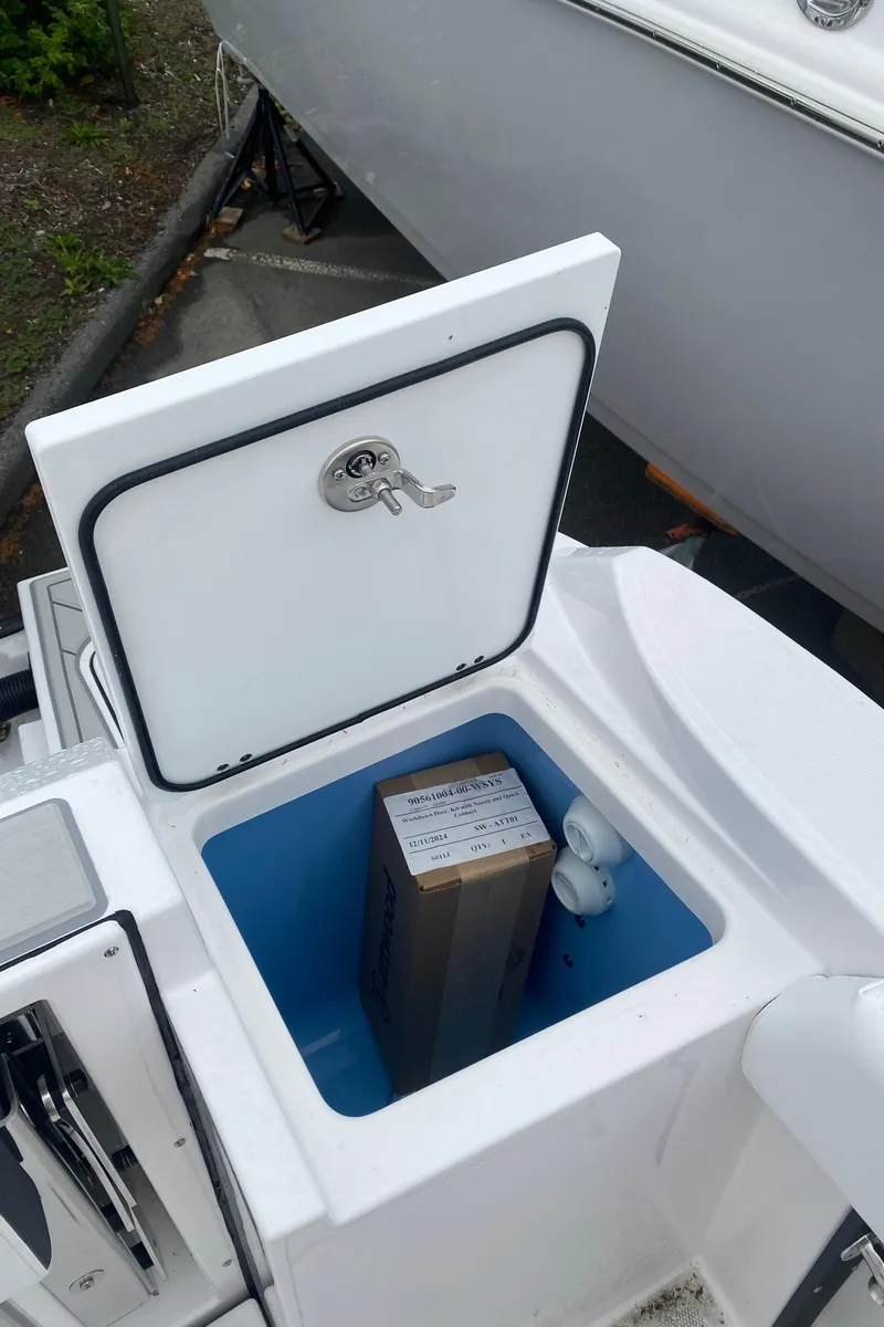 Slide: The Image of Open storage compartment on 2025 Blackfin 252 CC boat with a box inside. - 8