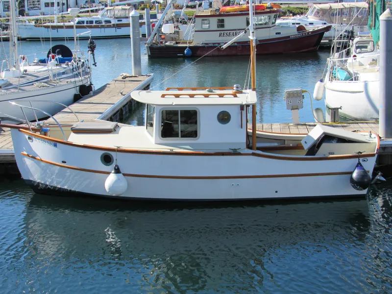 The Image of 1992 Devlin Surf Scoter boat docked in a marina, surrounded by other vessels. - 0