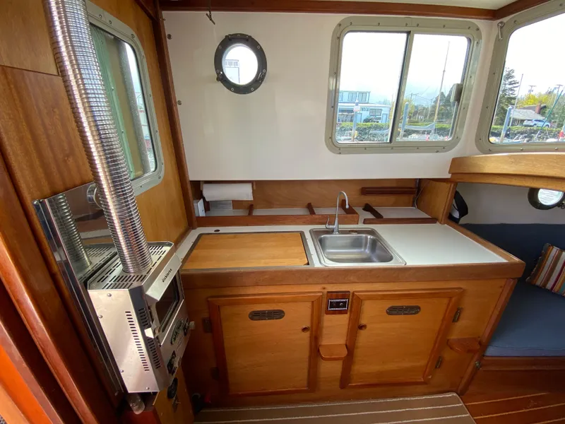 Slide: The Image of Interior of 1992 Devlin Surf Scoter boat with wooden cabinetry and compact kitchen area. - 15