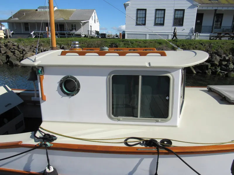 Slide: The Image of Devlin Surf Scoter 1992 boat with cabin, docked near waterfront houses. - 2