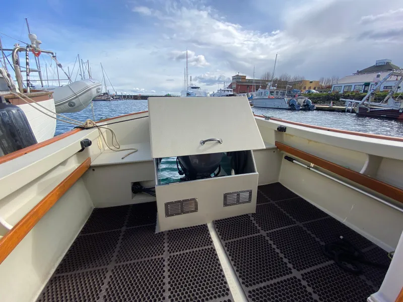 Slide: The Image of 1992 Devlin Surf Scoter boat interior at marina, featuring open seating and storage compartments. - 21