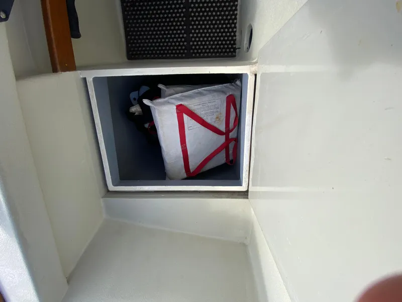 Slide: The Image of Storage compartment on a 1992 Devlin Surf Scoter boat with a life jacket inside. - 22