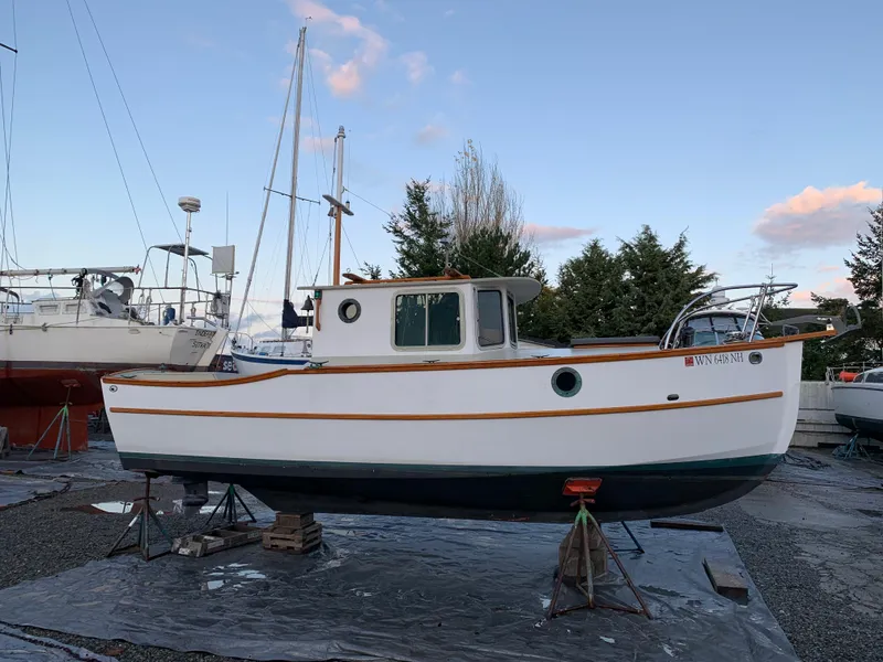 Slide: The Image of Devlin Surf Scoter 1992 boat on stands, surrounded by other vessels, under a clear sky. - 25