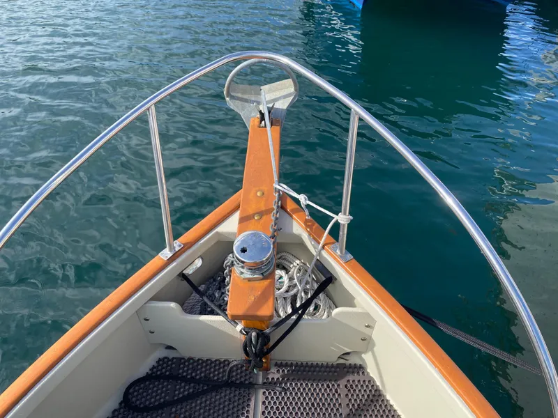 Slide: The Image of Bow of 1992 Devlin Surf Scoter boat with anchor and railing on calm water. - 4