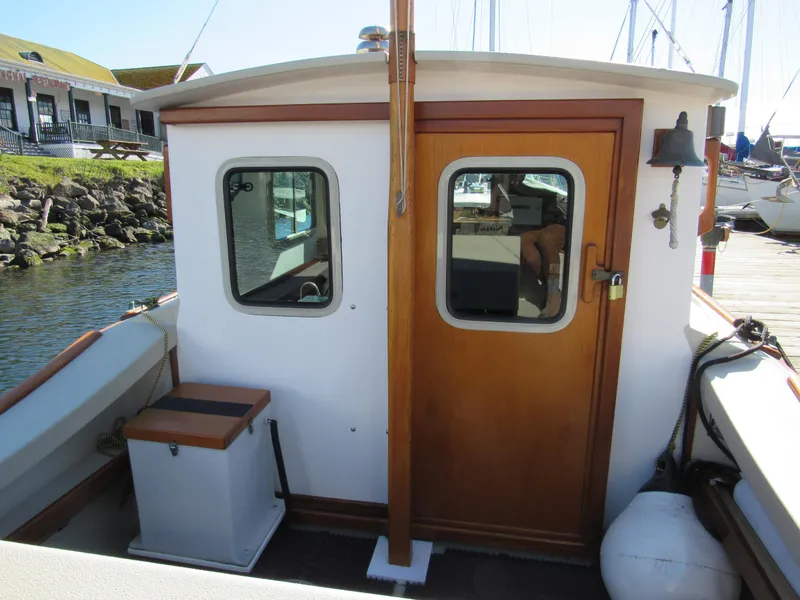 Slide: The Image of 1992 Devlin Surf Scoter boat cabin with wooden door and windows at a marina. - 6