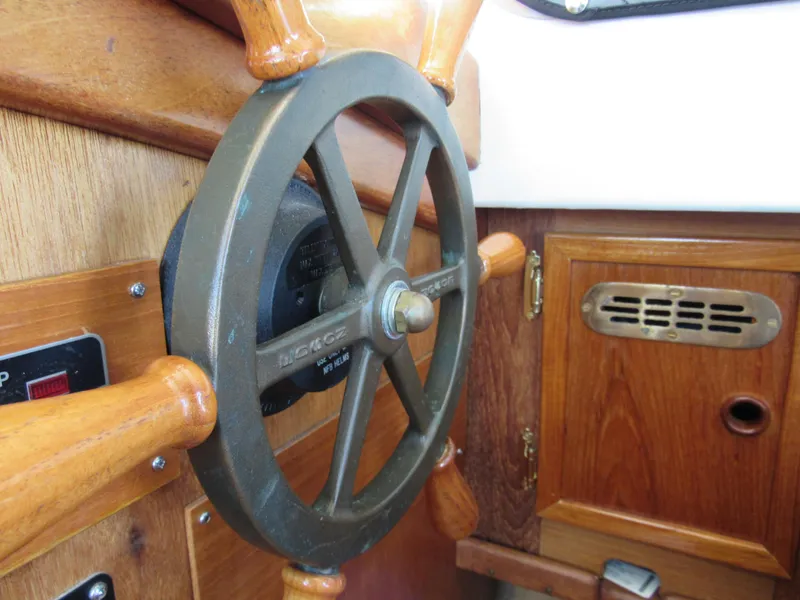 Slide: The Image of Steering wheel of a 1992 Devlin Surf Scoter boat, featuring wooden and metal elements. - 9