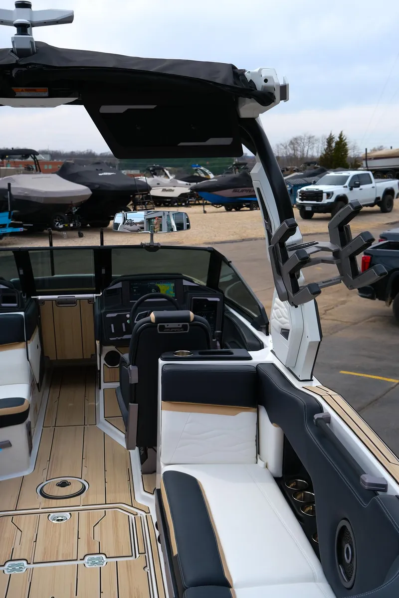 Slide: The Image of 2025 Supra SE450 boat interior with modern seating and dashboard, docked outdoors. - 10