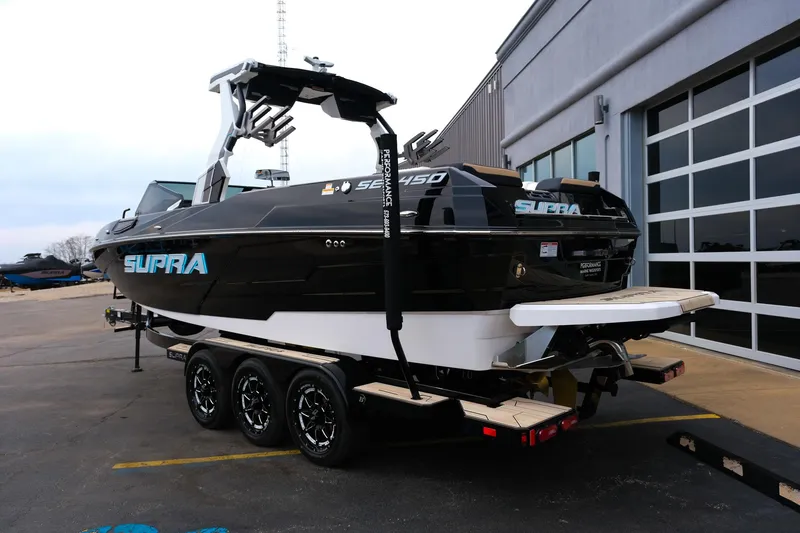 Slide: The Image of 2025 Supra SE450 boat on trailer, parked outside a building. - 3