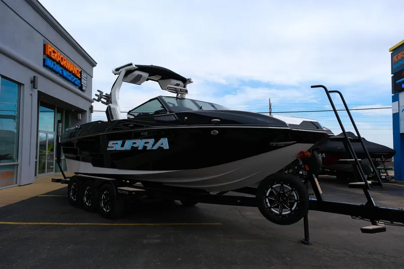 Slide: The Image of 2025 Supra SE450 boat on trailer outside dealership. - 34
