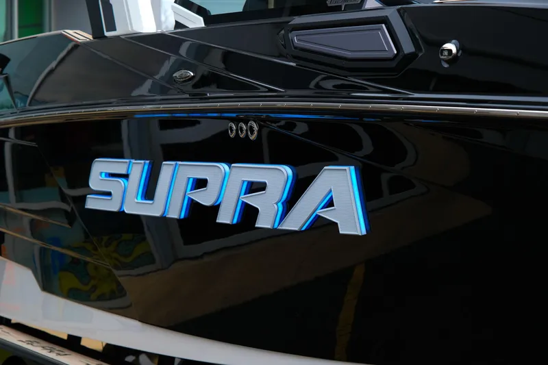 Slide: The Image of 2025 Supra SE450 boat with sleek black exterior and illuminated logo. - 35