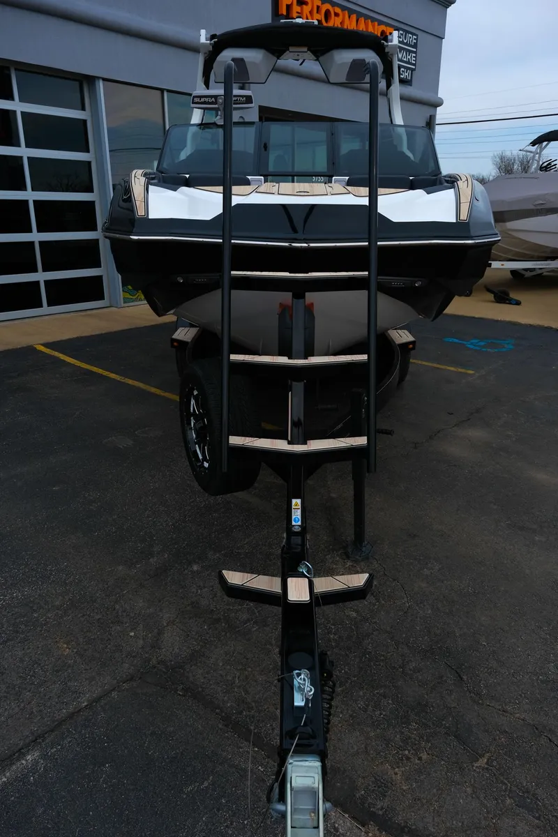Slide: The Image of 2025 Supra SE450 boat on trailer, parked outside dealership. - 36
