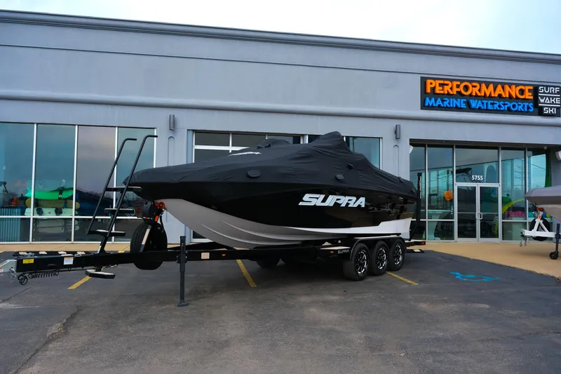 Slide: The Image of 2025 Supra SE450 boat covered, parked outside Performance Marine Watersports store. - 37
