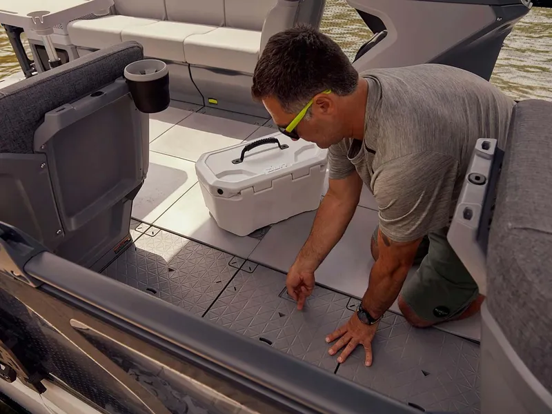 Slide: The Image of Man adjusting floor panel on 2024 Sea-Doo Switch Cruise 21 boat interior. - 4