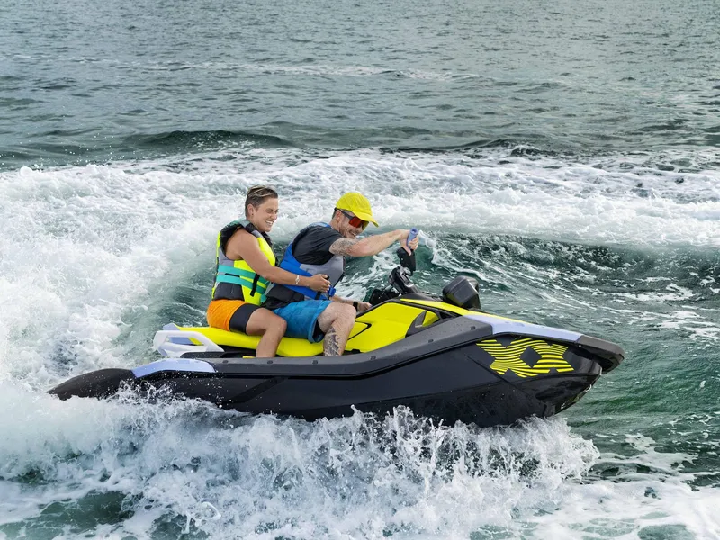 Slide: The Image of 2024 Sea-Doo Spark Trixx 3up iBR with Sound System on water, two riders enjoying. - 3