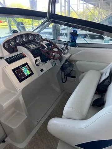 Slide: The Image of 2009 Crownline 340 CR boat cockpit with modern controls and white seating. - 10