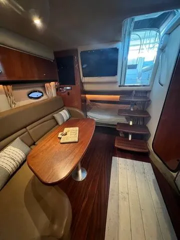 Slide: The Image of Interior of 2009 Crownline 340 CR yacht with wooden table and stairs. - 11