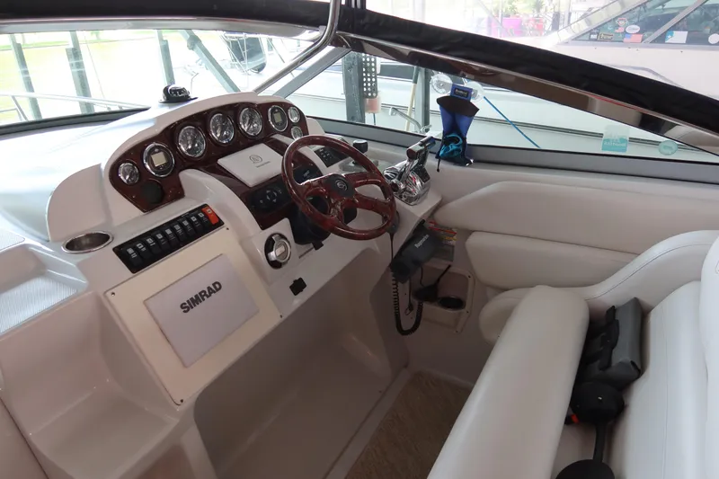 Slide: The Image of 2009 Crownline 340 CR boat cockpit with steering wheel and Simrad navigation system. - 19