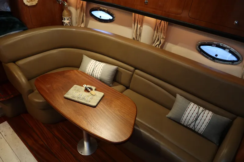 Slide: The Image of 2009 Crownline 340 CR interior with leather seating and wooden table. - 22