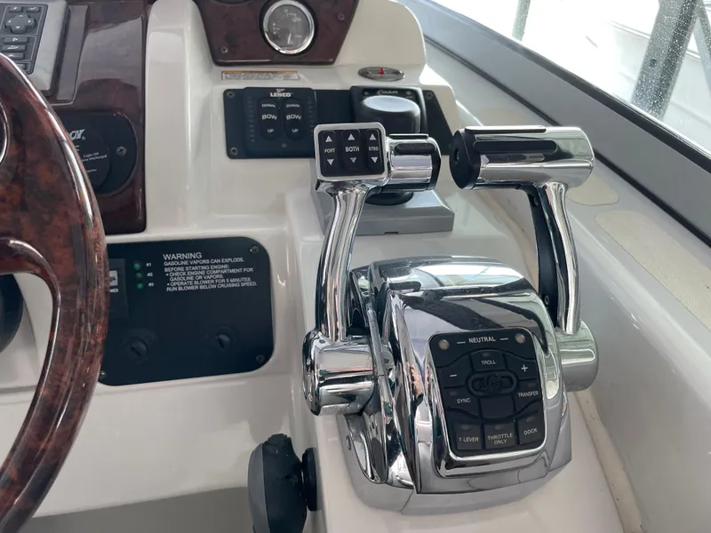 Slide: The Image of 2009 Crownline 340 CR boat controls with chrome throttle levers and dashboard instruments. - 38