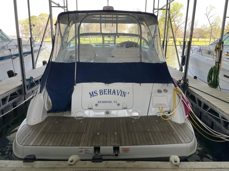 Slide: The Image of 2009 Crownline 340 CR boat docked, rear view with canopy and "MS BEHAVIN" name displayed. - 4