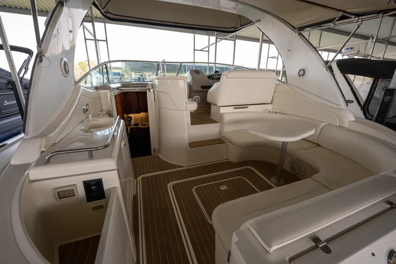 Slide: The Image of 2004 Cruisers Yachts 370 Express interior with seating and table in a covered dock. - 33