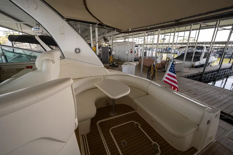 Slide: The Image of 2004 Cruisers Yachts 370 Express interior with seating and American flag at marina. - 34
