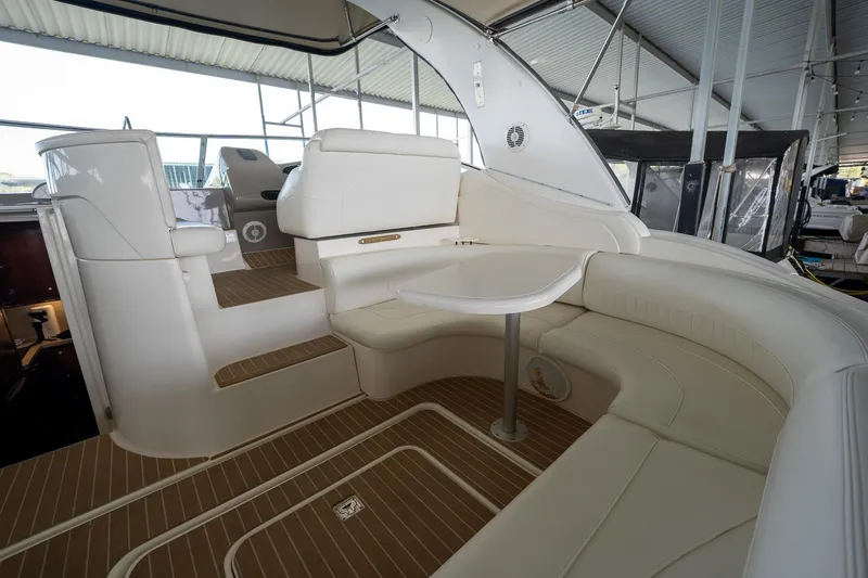 Slide: The Image of 2004 Cruisers Yachts 370 Express interior with white seating and table in a covered marina. - 37