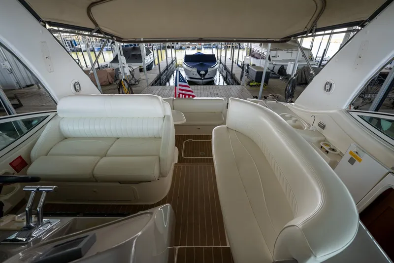 Slide: The Image of 2004 Cruisers Yachts 370 Express interior with white seating and dock view. - 41