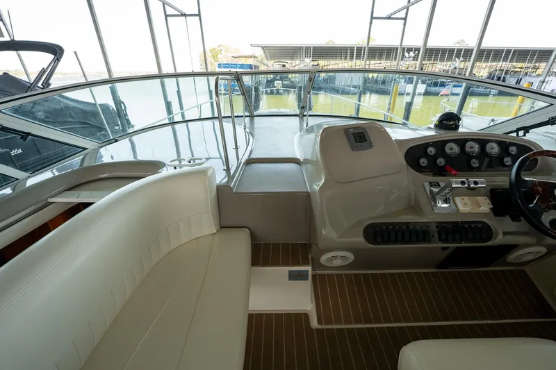 Slide: The Image of 2004 Cruisers Yachts 370 Express cockpit with helm, seating, and marina view. - 45