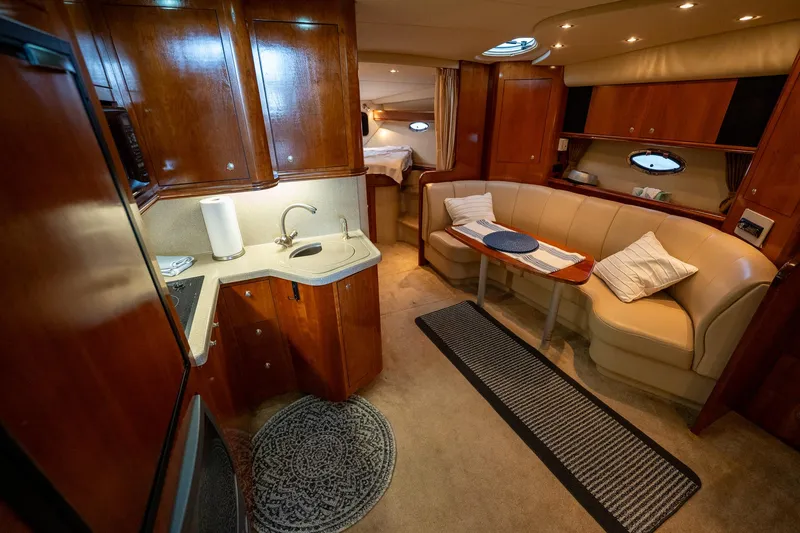 Slide: The Image of Interior of 2004 Cruisers Yachts 370 Express, featuring kitchen and seating area. - 49