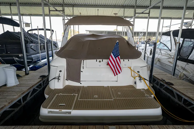 Slide: The Image of 2004 Cruisers Yachts 370 Express docked, covered, with American flag displayed. - 17