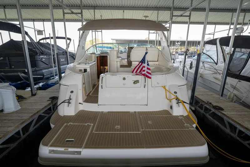 Slide: The Image of 2004 Cruisers Yachts 370 Express docked, rear view with American flag, under covered marina. - 25