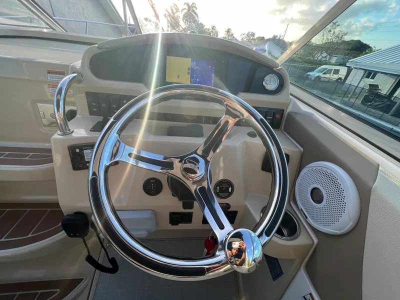 Slide: The Image of 2020 Regal 26 XO boat helm with steering wheel and control panel. - 16