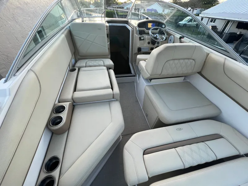 Slide: The Image of 2020 Regal 26 XO boat interior with beige seating and cup holders. - 26