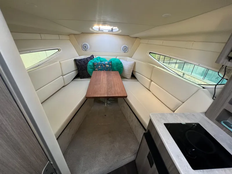 Slide: The Image of 2020 Regal 26 XO cabin interior with seating, table, and kitchenette. - 28