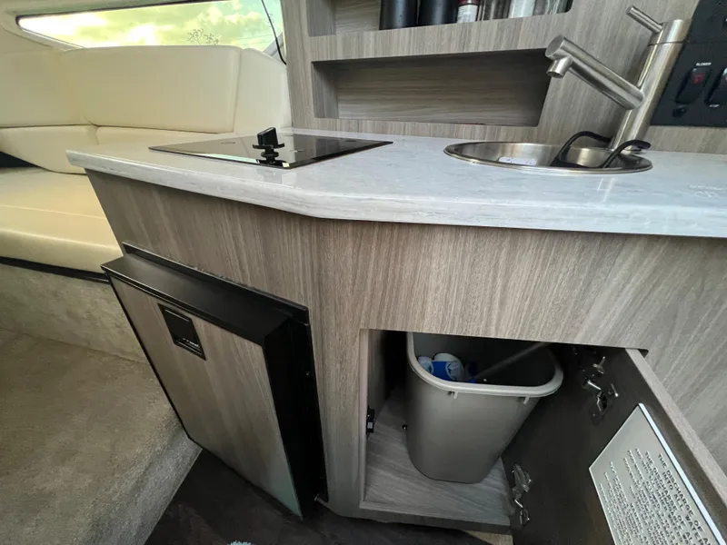 Slide: The Image of 2020 Regal 26 XO boat interior with kitchenette, sink, and mini fridge. - 38