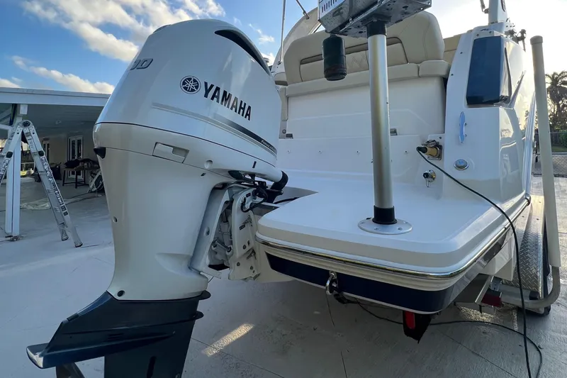 Slide: The Image of 2020 Regal 26 XO boat with Yamaha outboard motor, docked under a blue sky. - 8