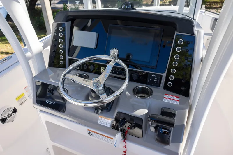 Slide: The Image of 2020 Robalo R230 Center Console boat dashboard with steering wheel and control panel. - 10