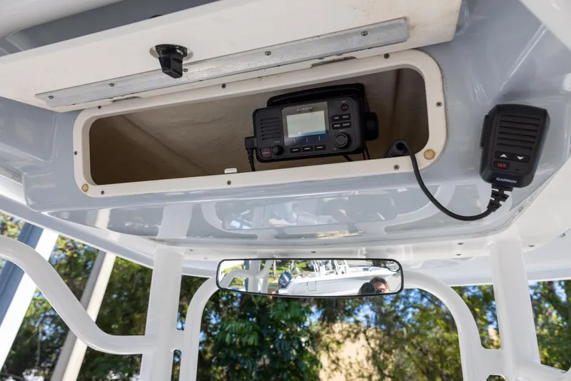 Slide: The Image of 2020 Robalo R230 Center Console boat with radio equipment in storage compartment. - 11