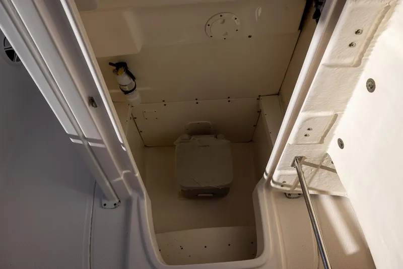Slide: The Image of 2020 Robalo R230 Center Console boat interior with portable toilet. - 15
