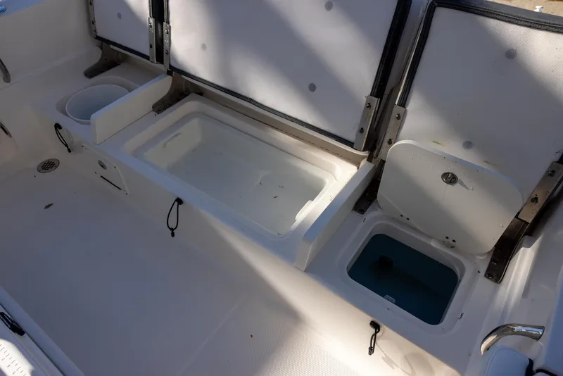 Slide: The Image of 2020 Robalo R230 Center Console boat interior with storage compartments and seating. - 8